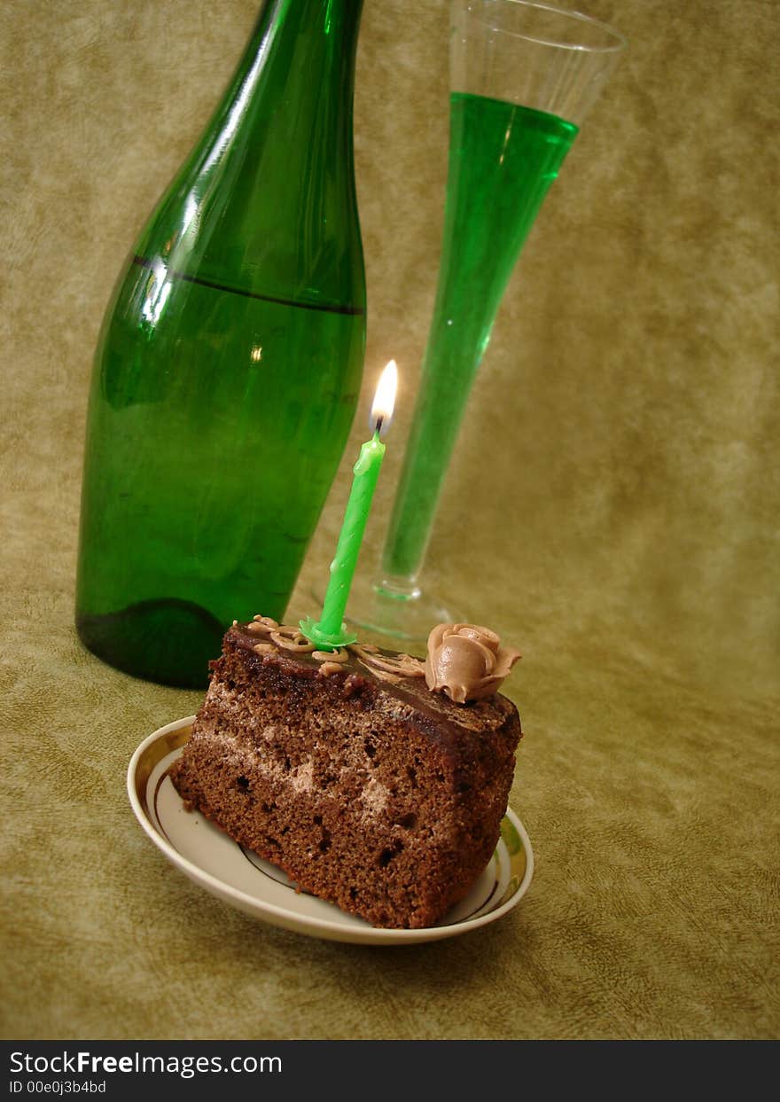 Celebratory table (Chocolate cake with candle and green bottle)