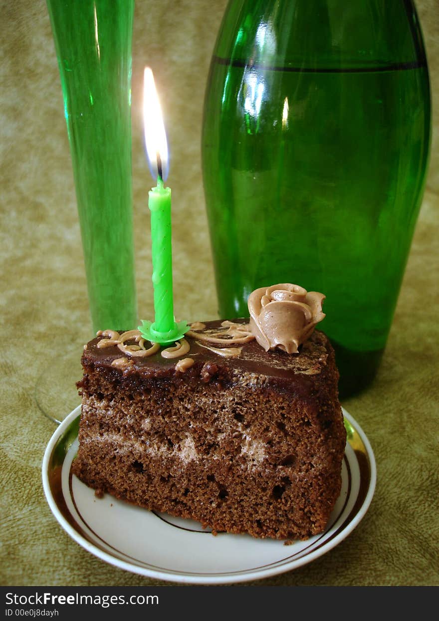 Celebratory table (Chocolate cake with candle and green bottle)