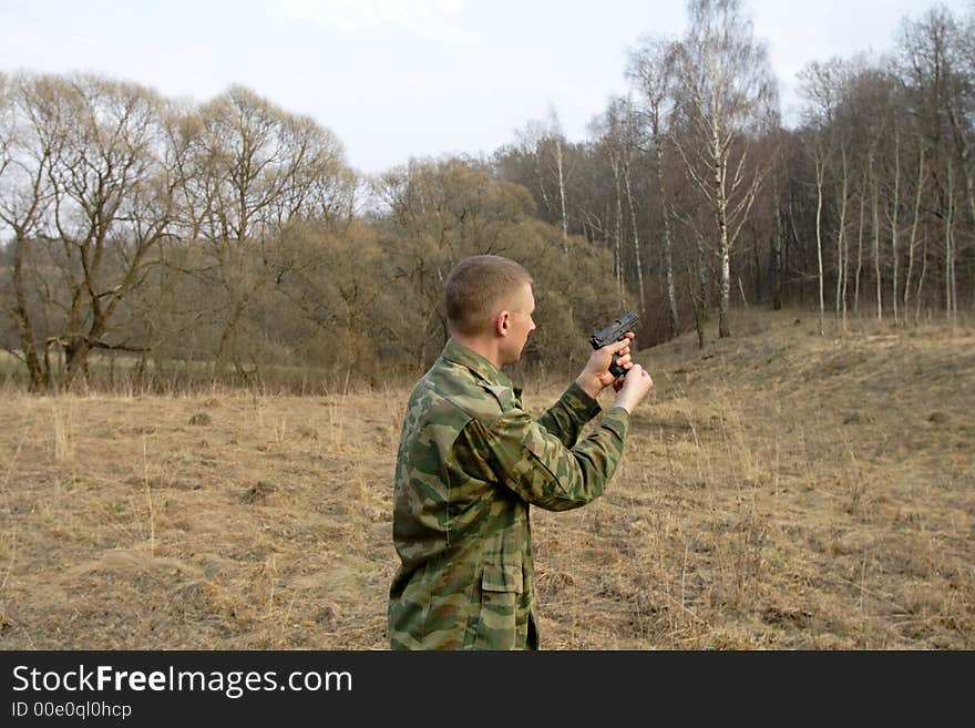 Man shoots from a pistol in a wood. Man shoots from a pistol in a wood