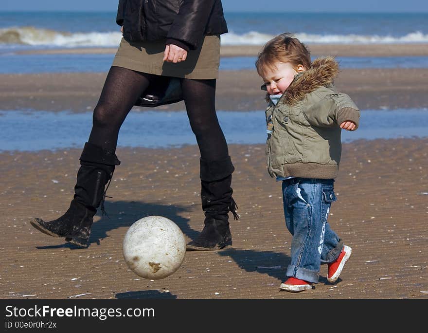 Young boy playing soccer on the beach