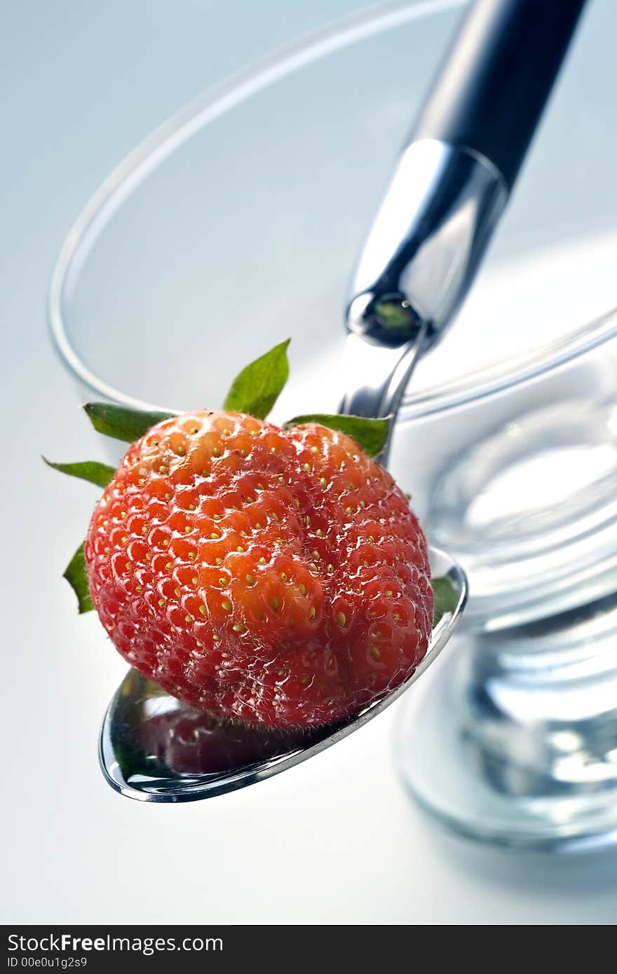 Delightful strawberry in strict laying on the spoon and a glass