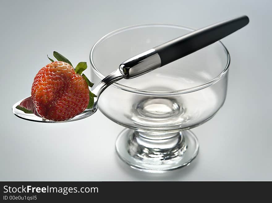 Delightful strawberry in strict laying on the spoon and a glass