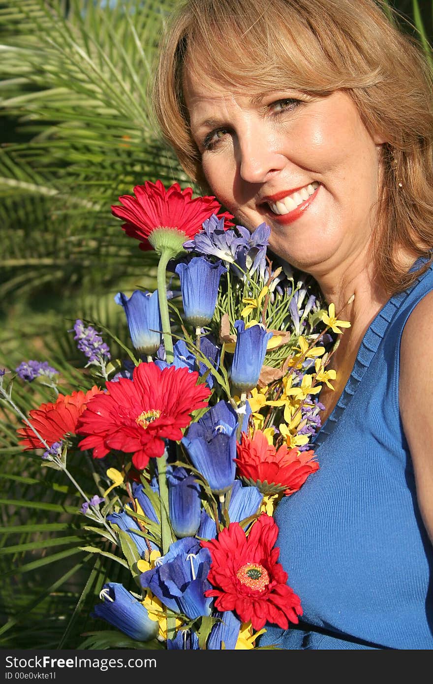 Gorgeous fifty year old woman with flowers vertical