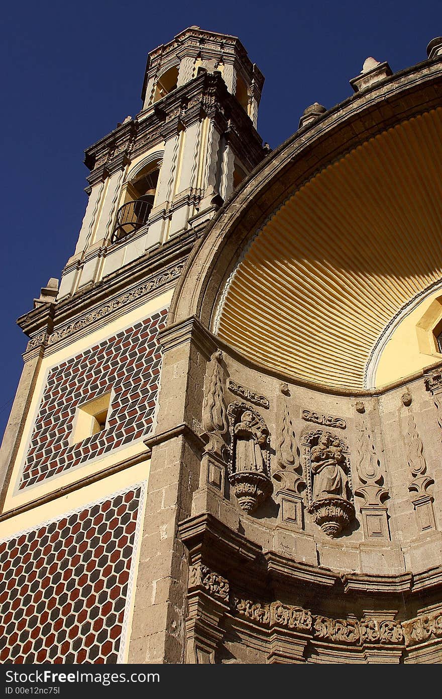 Partial view of the tower and entrance door of a colonial church the San Juan de Dios church down town Mexico city, Mexico, Latin America. Partial view of the tower and entrance door of a colonial church the San Juan de Dios church down town Mexico city, Mexico, Latin America