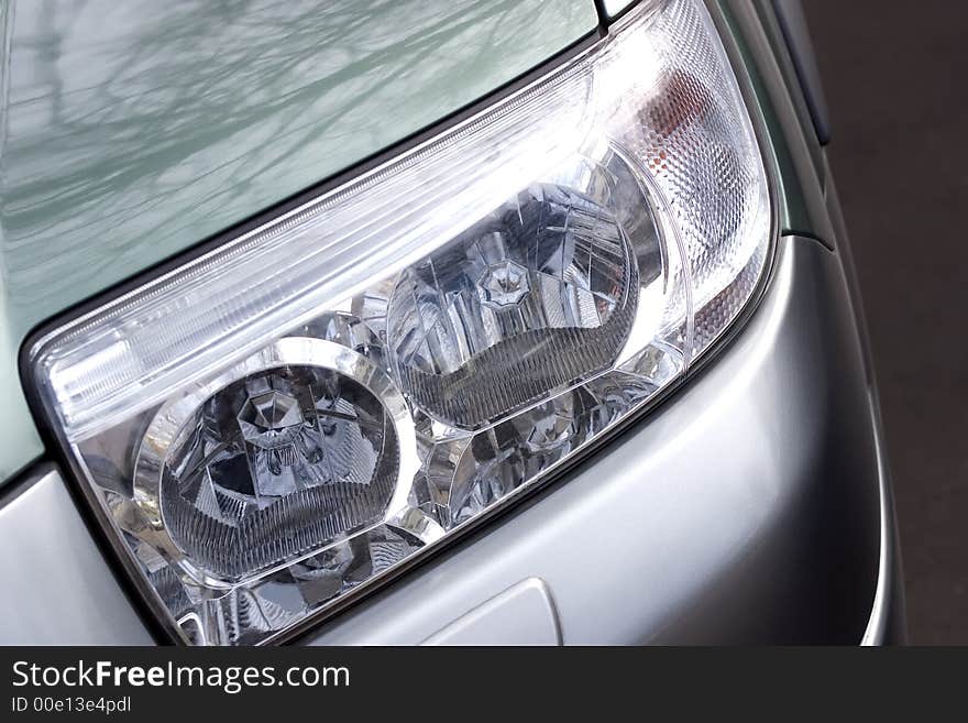 Vehicle shiny headlight close-up shot. Vehicle shiny headlight close-up shot