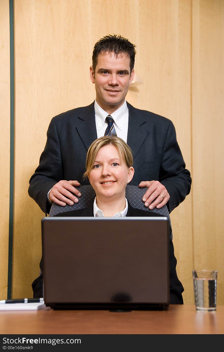 Man and woman in a business room with a laptop. Man and woman in a business room with a laptop