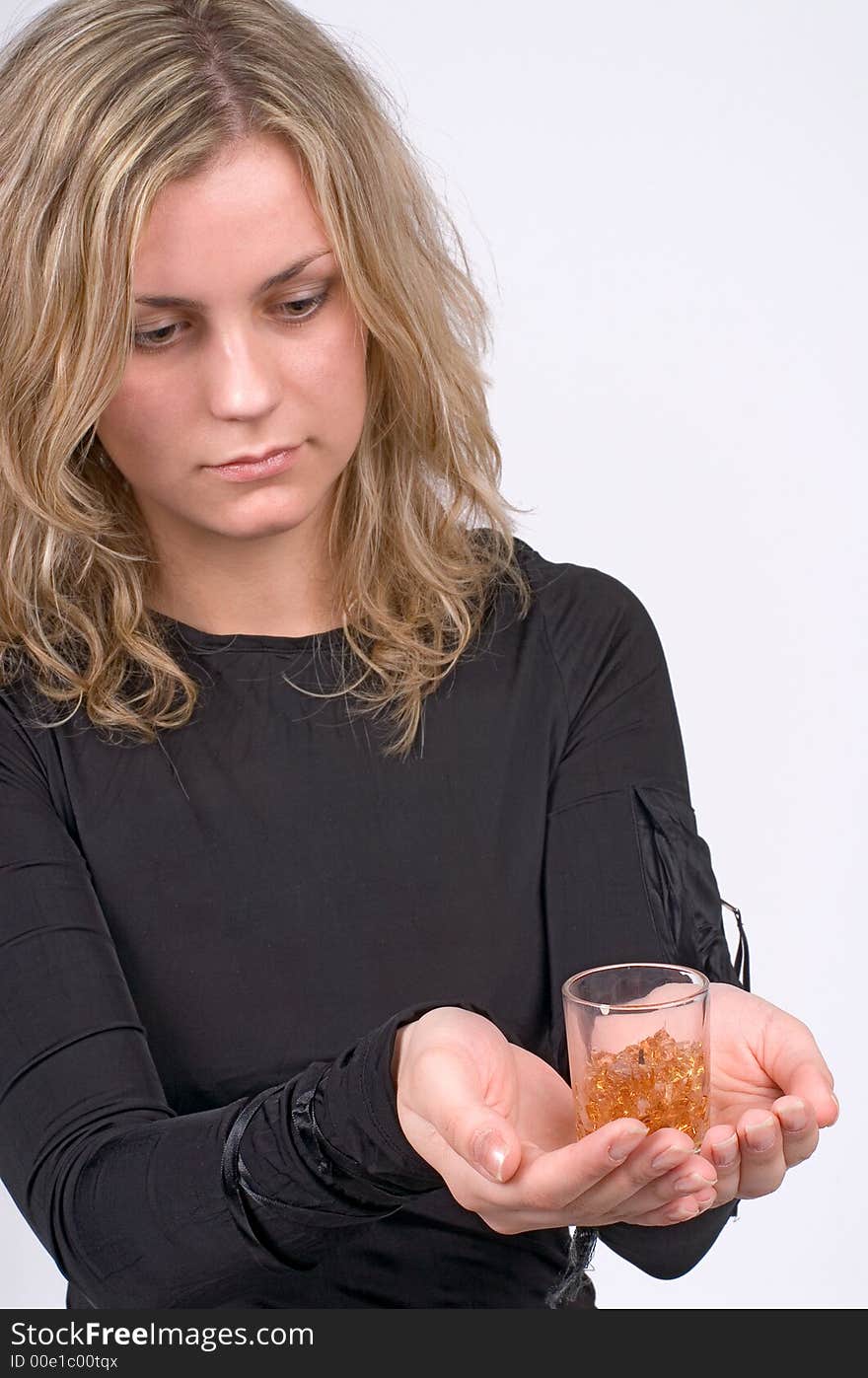 The girl looks at a candle in a hand on a grey background. The girl looks at a candle in a hand on a grey background