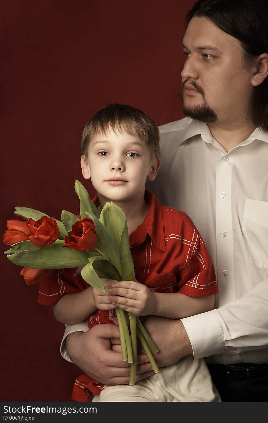 father and son keeping bouquet of red tulips. father and son keeping bouquet of red tulips