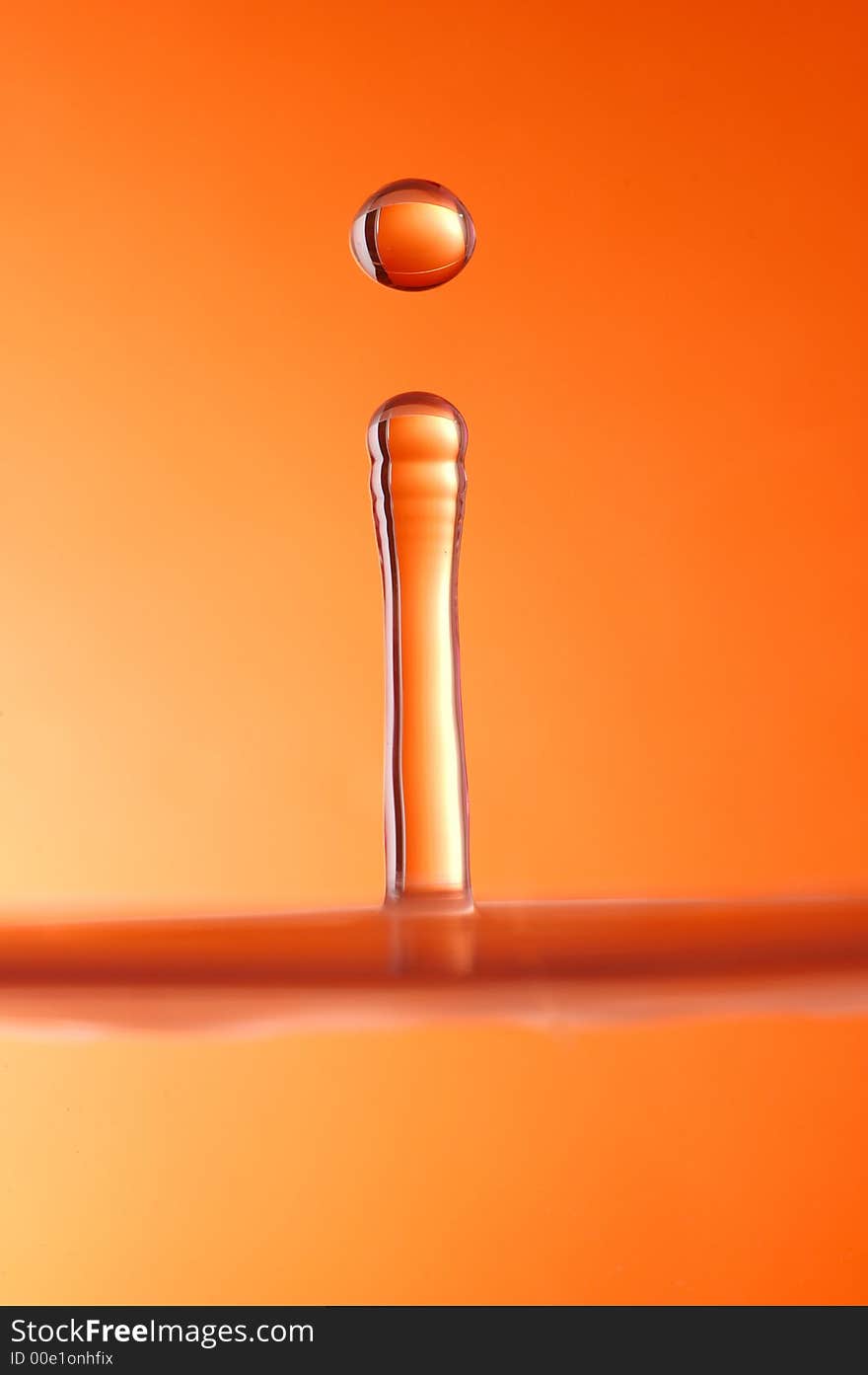 Water droplet over orange background, high speed photography.