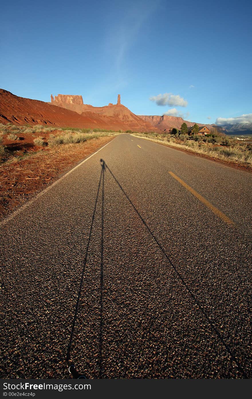 Desert road with tripod shadow