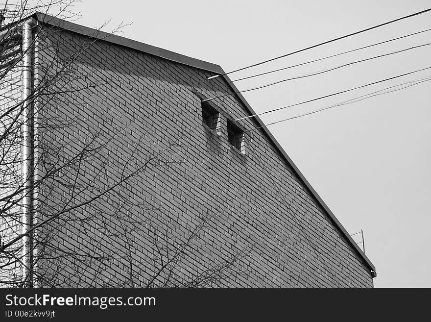 A roof fragment of old house with a brick wall. A roof fragment of old house with a brick wall