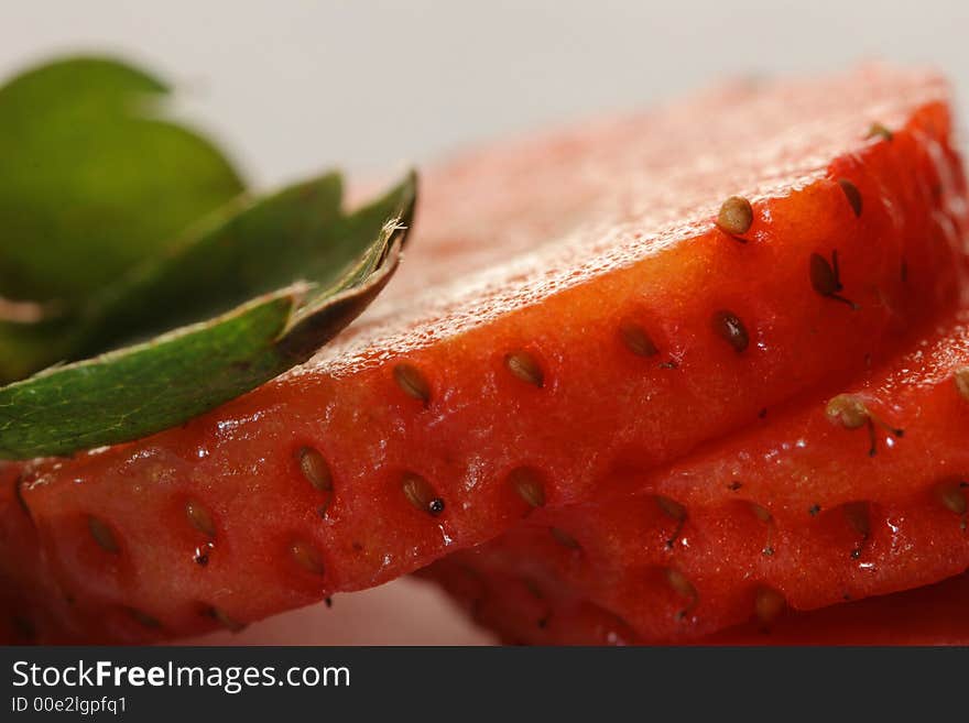 Segments of ripe cut strawberry with leaves. Segments of ripe cut strawberry with leaves