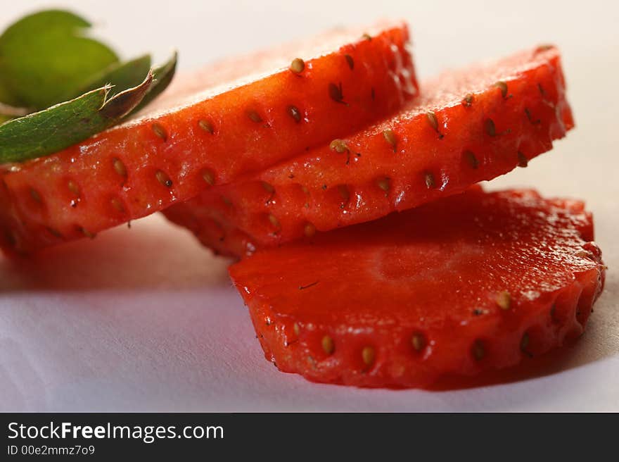 Segments of ripe cut strawberry with leaves. Segments of ripe cut strawberry with leaves