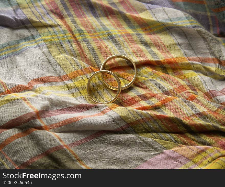 Two wedding rings on a colourful cloth background. Two wedding rings on a colourful cloth background