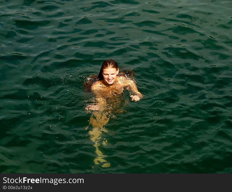 Young nude woman in the sea