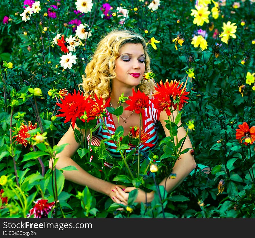 Beautiful girl hugging dahlia flowers on flowers garden