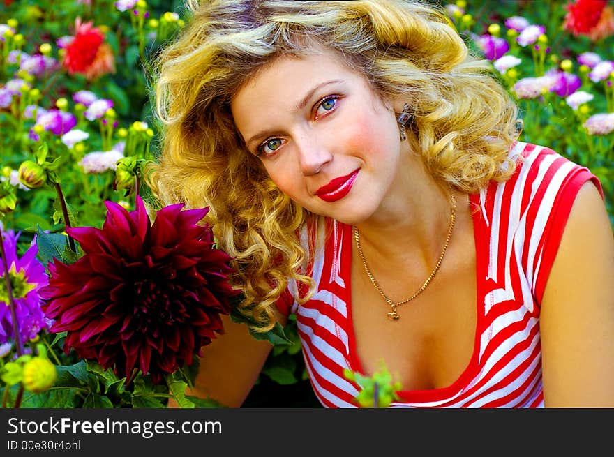 Beautiful girl among dahlia flowers meadow