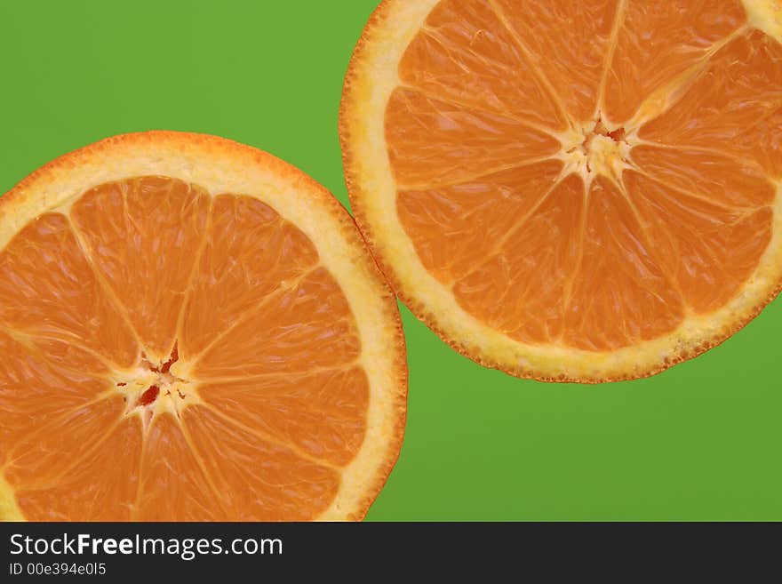 Two oranges with green background