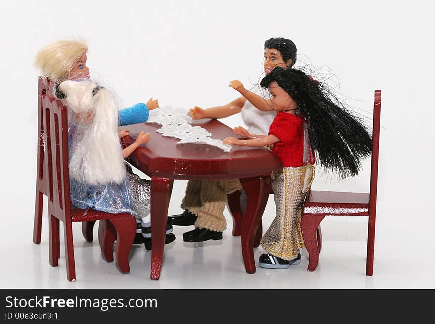 A macro shot of a toy family sitting at a dining table. isoalated on white. A macro shot of a toy family sitting at a dining table. isoalated on white