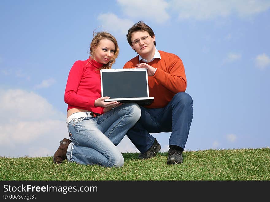 Couple with notebook on meadow