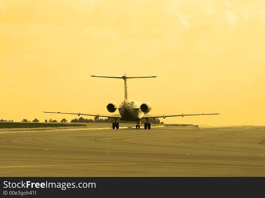 Photo of an airplane landing at sunset