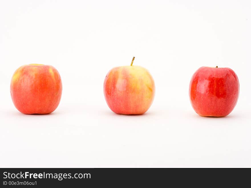 Three Pink Lady apples in a horizontal line