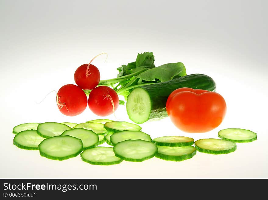 Green Cucumber and red radish and red tomato on white background. Green Cucumber and red radish and red tomato on white background