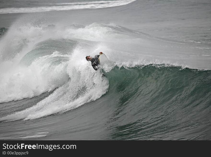 Photo of a bodyboarder on top of the wave