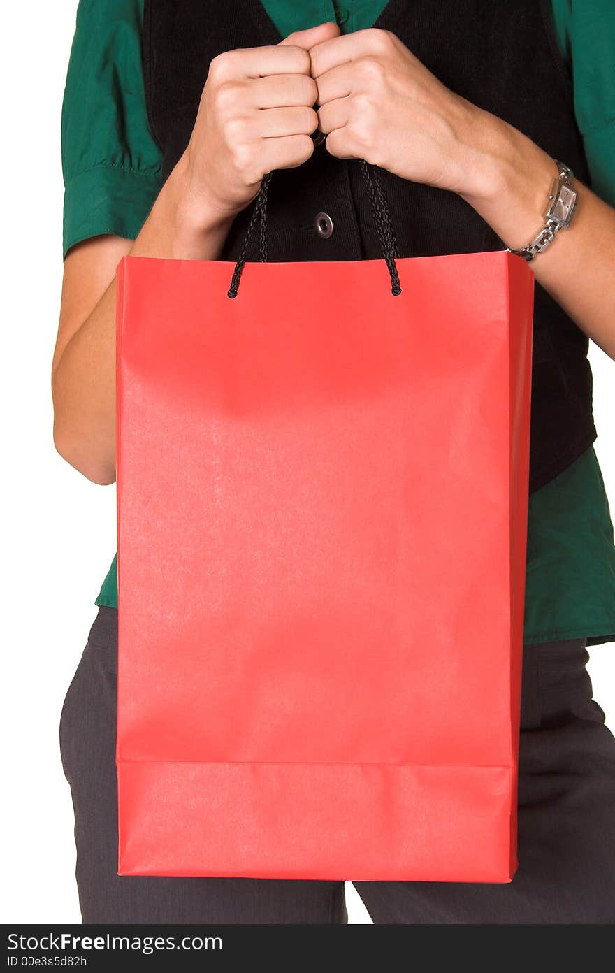 Young adult woman holding a red paper shopping bag in front of her. She is wearing a green shirt, black waist-coat and grey trousers. Image is isolated on a white background. Young adult woman holding a red paper shopping bag in front of her. She is wearing a green shirt, black waist-coat and grey trousers. Image is isolated on a white background