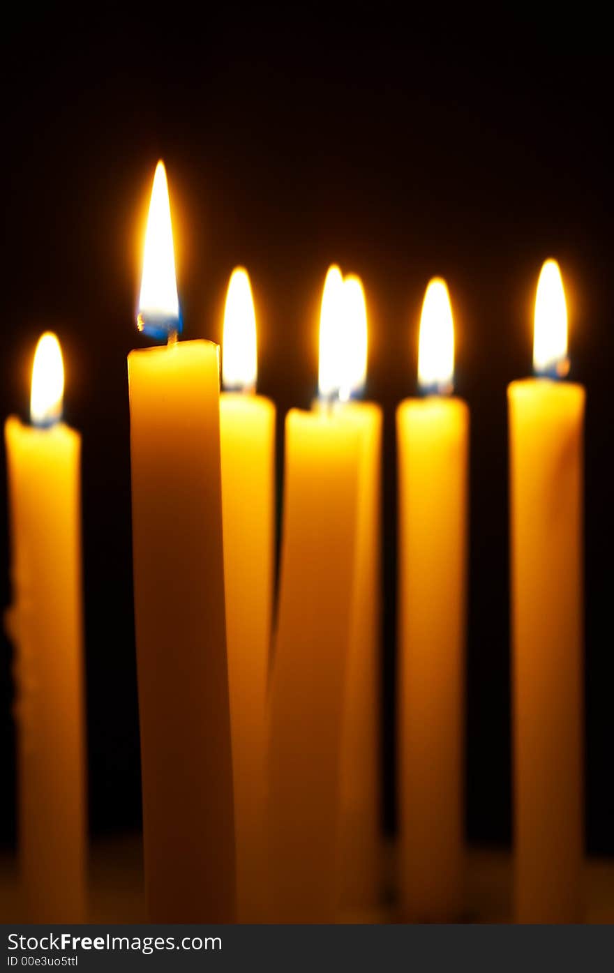 Romantic burning candles on black background