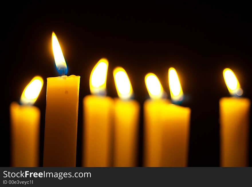 Romantic burning candles on black background