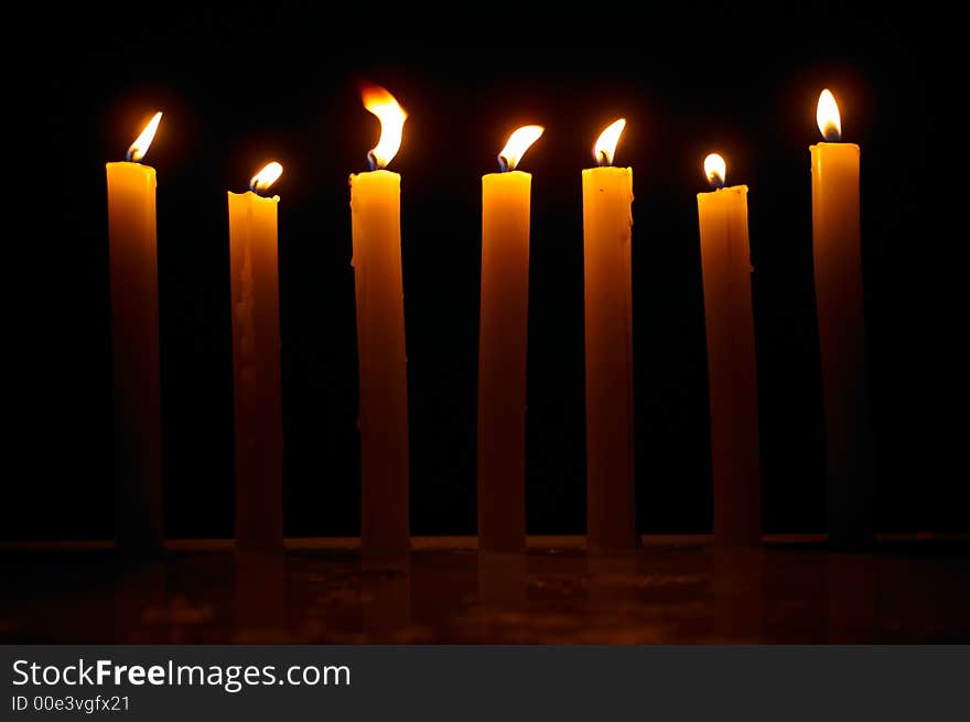 Romantic burning candles on black background