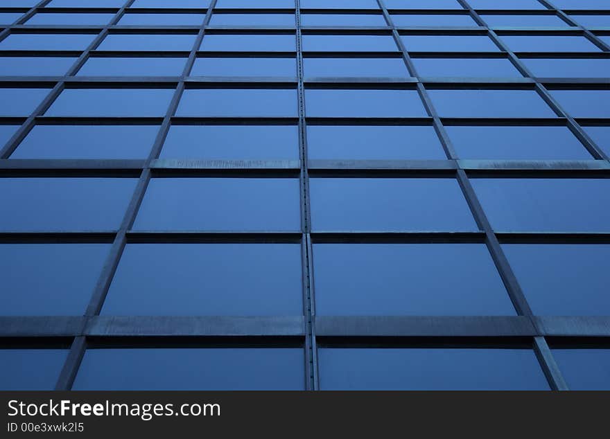 Blue glass panels of a skyscraper, perspective view.