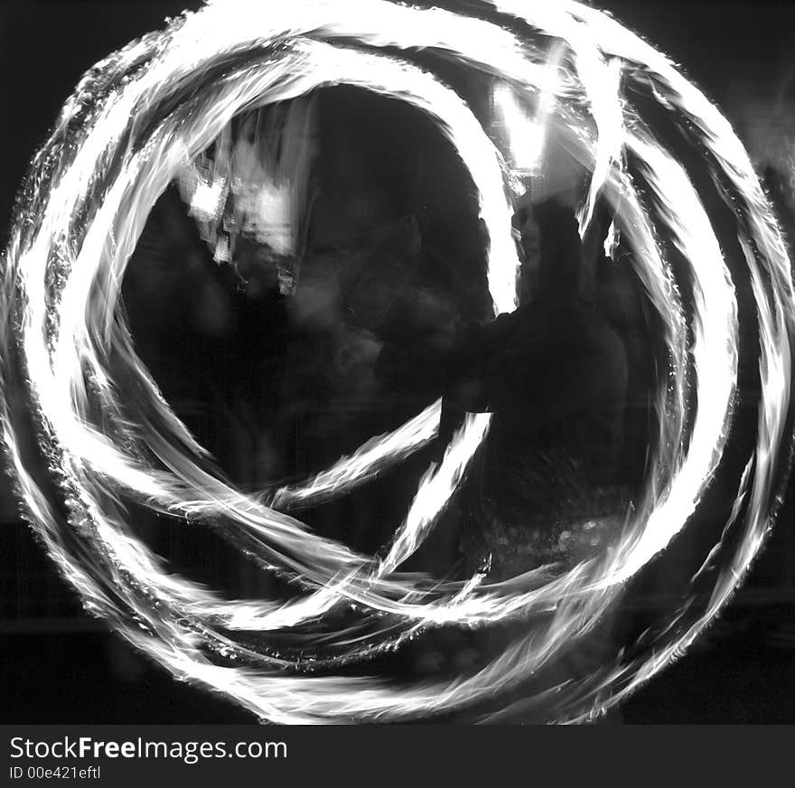 Blurred image of person swinging fire poi during a New Year parade. Blurred image of person swinging fire poi during a New Year parade