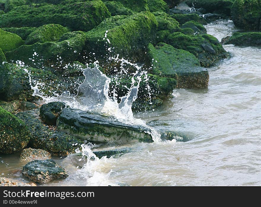 Wave crashing against some rocks. Wave crashing against some rocks