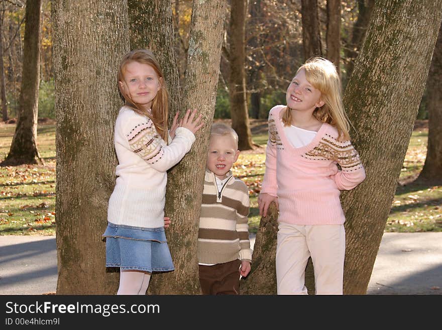 Two sisters and their brother standing in a tree. Two sisters and their brother standing in a tree