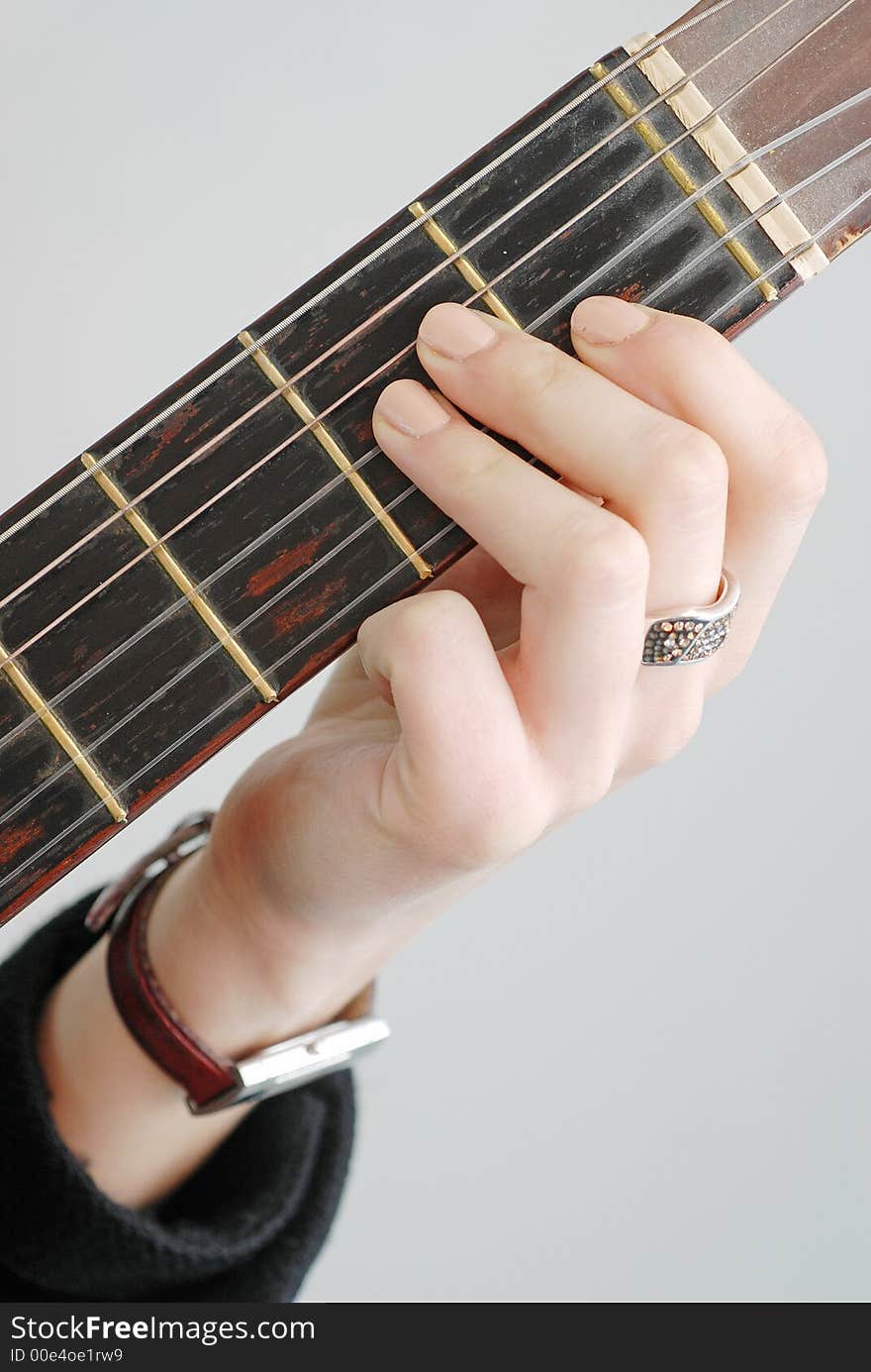 Female fingers play over guitar