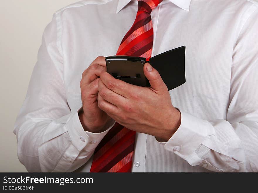 A man in shirt and tie writing on a pda. A man in shirt and tie writing on a pda