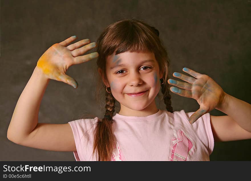 The good little girl. Hands and the face are soiled in a paint. The good little girl. Hands and the face are soiled in a paint