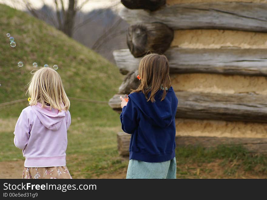 Two young girls playing with bubbles. Two young girls playing with bubbles