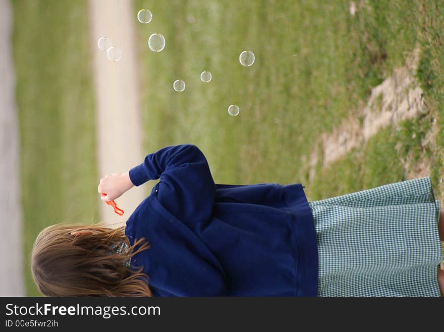 Young girl plays with bubble wand. Young girl plays with bubble wand