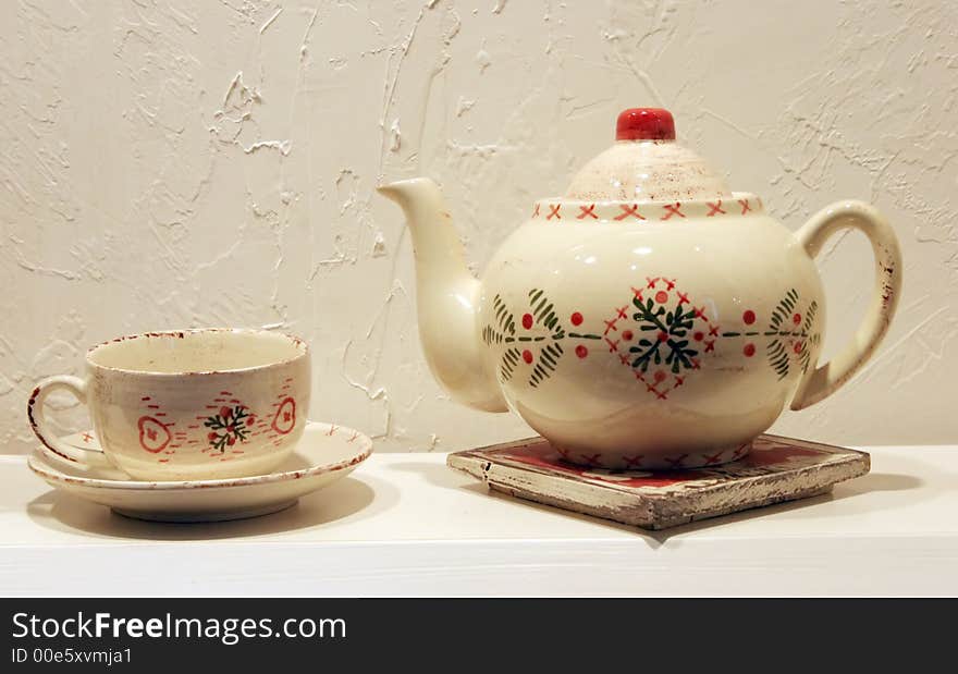 White teapot and cup on a shelf. White teapot and cup on a shelf