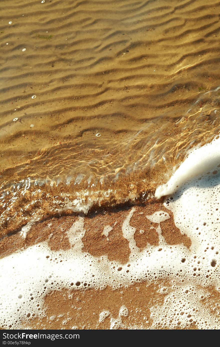 Light wave with foam on a lake in summer