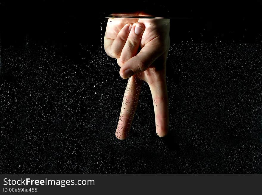 Photo of hand in the water on a black background.