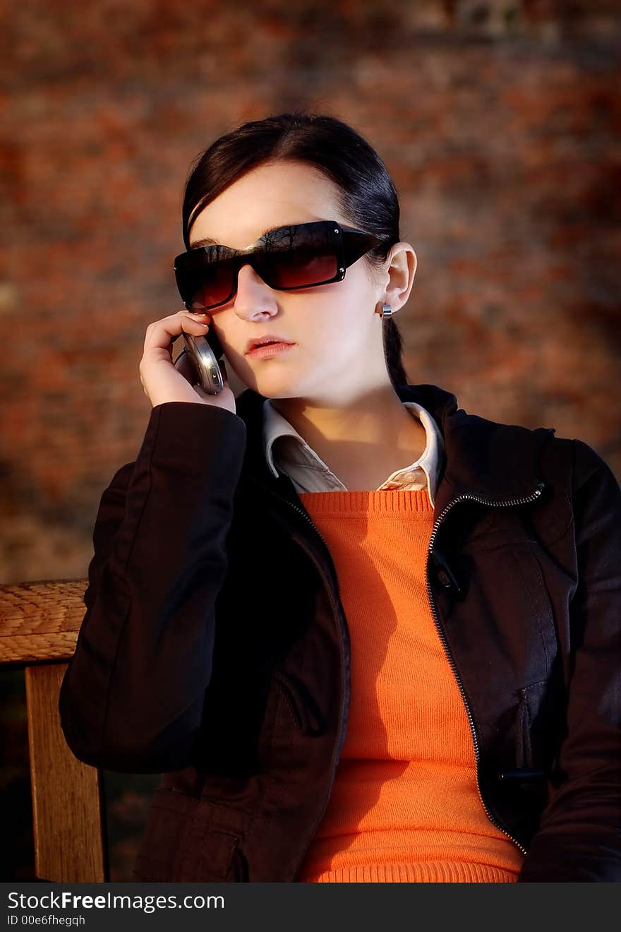 Photo of pretty female in sunshine light with cell phone. Photo of pretty female in sunshine light with cell phone.