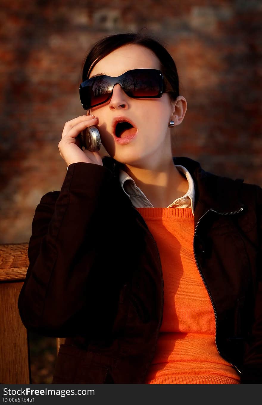 Photo of pretty female in sunshine light with cell phone. Photo of pretty female in sunshine light with cell phone.