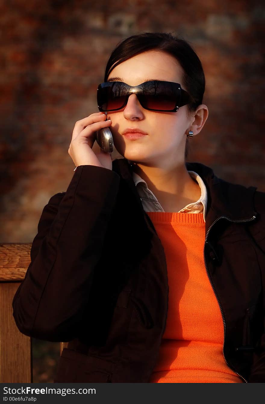 Photo of pretty female in sunshine light with cell phone. Photo of pretty female in sunshine light with cell phone.