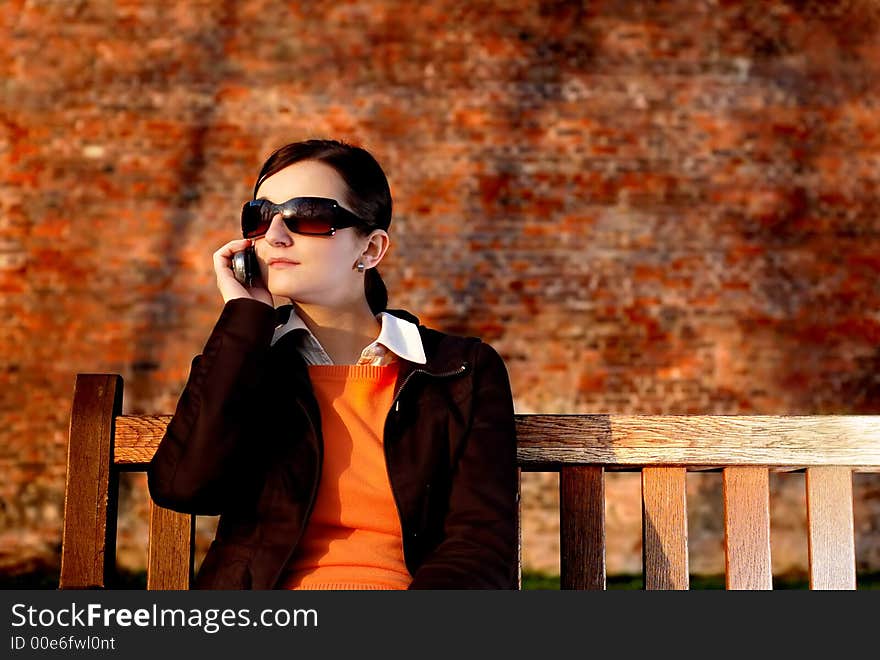 Photo of pretty female in sunshine light with cell phone. Photo of pretty female in sunshine light with cell phone.