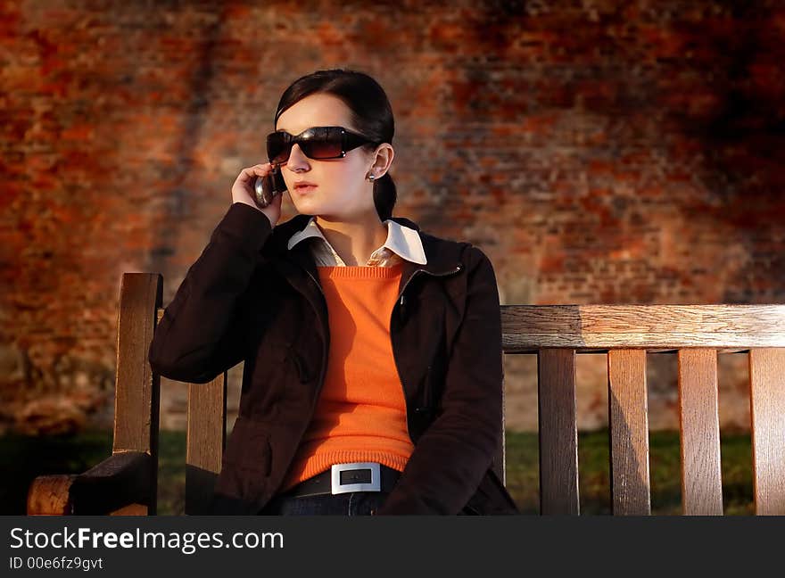 Photo of pretty female in sunshine light with cell phone. Photo of pretty female in sunshine light with cell phone.