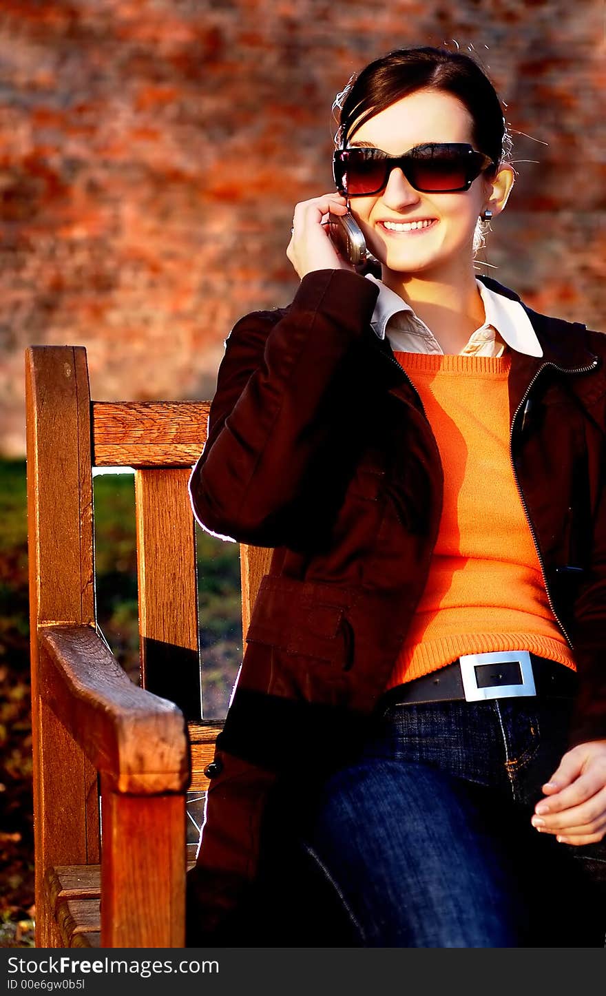 Photo of pretty female in sunshine light with cell phone. Photo of pretty female in sunshine light with cell phone.